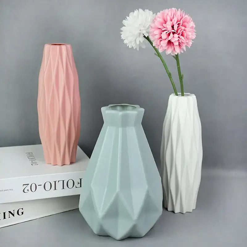 Three geometrically faceted pastel pink mint green and white colorful plastic flower vases for modern home décor