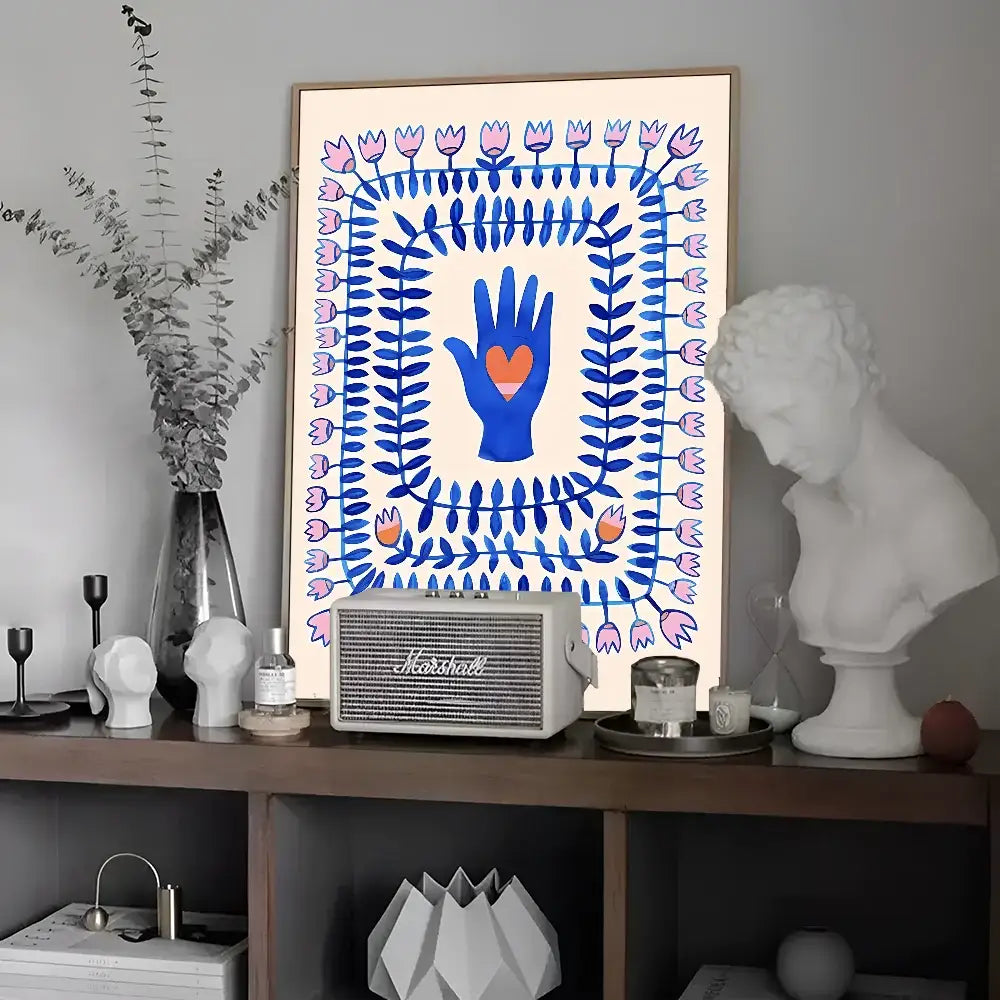 A framed wall art featuring a blue hand with an orange heart and floral patterns in a colorful leopard vintage poster style