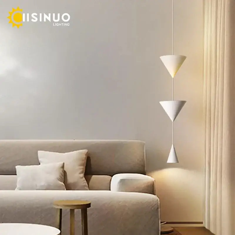 Decorbites cone pendant light featuring a white geometric design with three stacked conical shades suspended by a thin cord