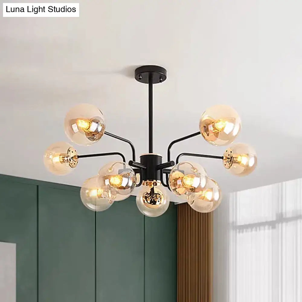 DecorBites™ black metal chandelier with amber glass shade spheres emitting warm light for living room ceiling decor