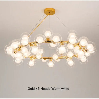 Gold-toned decorbites™ chandelier with 45 clear white glass balls emitting warm white light in black and gold design