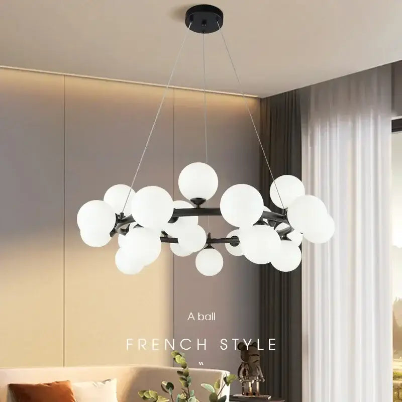 Modern black metal chandelier with clustered white glass ball globes in black and gold finish by decorbites