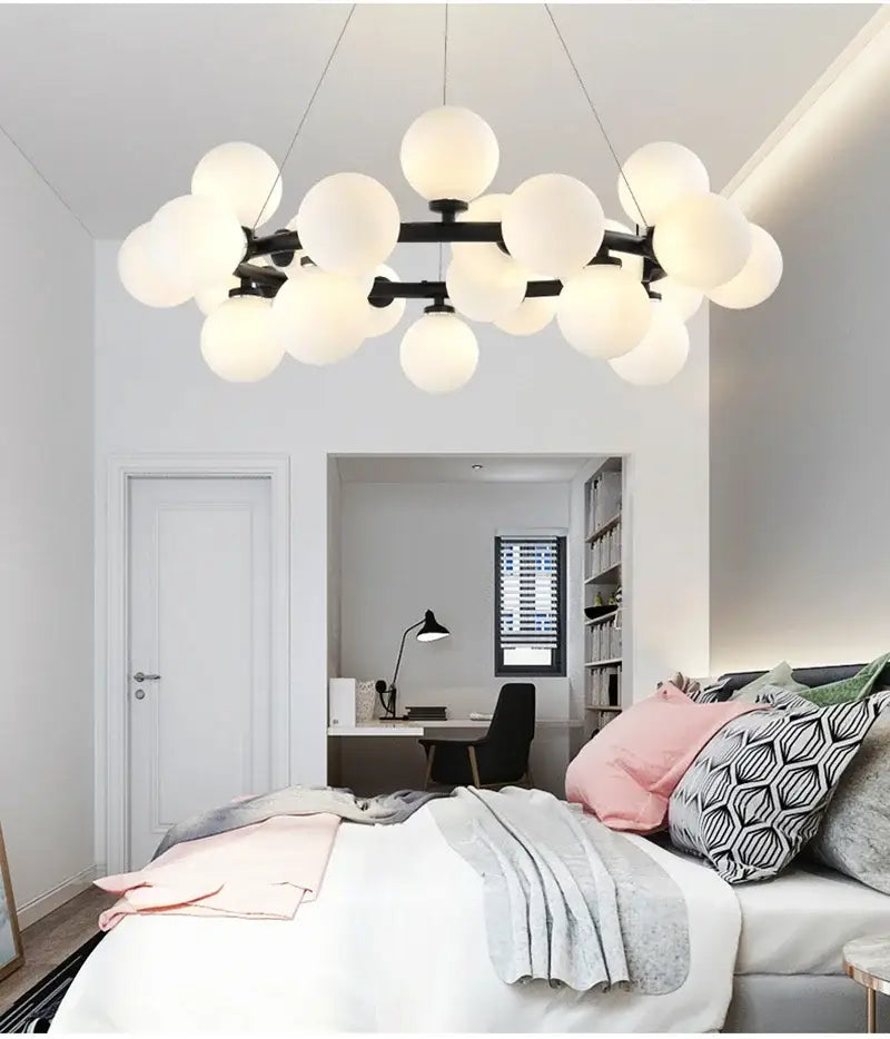 Modern black metal chandelier by DecorBites with frosted white glass balls and gold accents for contemporary decor