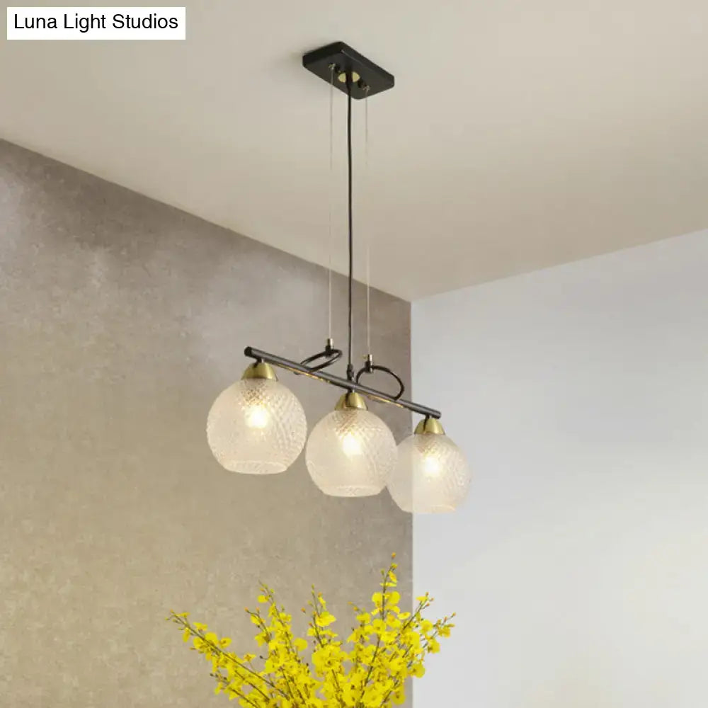Modern black metal pendant light with three frosted clear prismatic glass globes for dining hall illumination