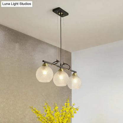 Modern black metal pendant light with three frosted clear prismatic glass globes for dining hall illumination