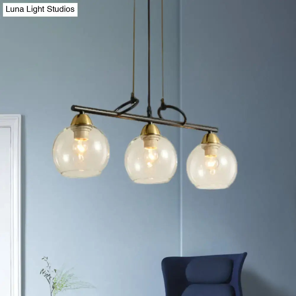 Modern three-light black pendant chandelier with clear prismatic glass and brass accents for dining hall lighting