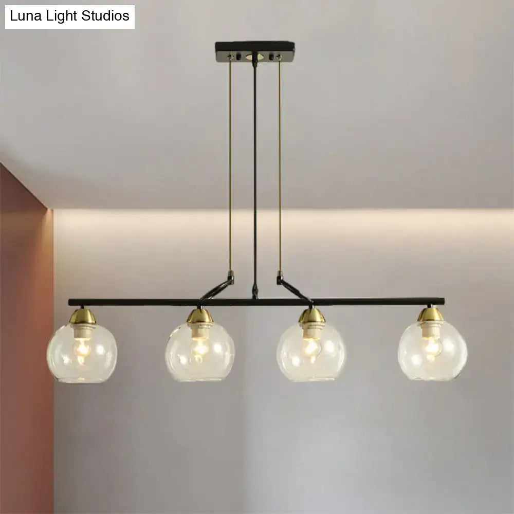 Black metal bar pendant light with four clear prismatic glass globe shades and brass accents for dining hall lighting