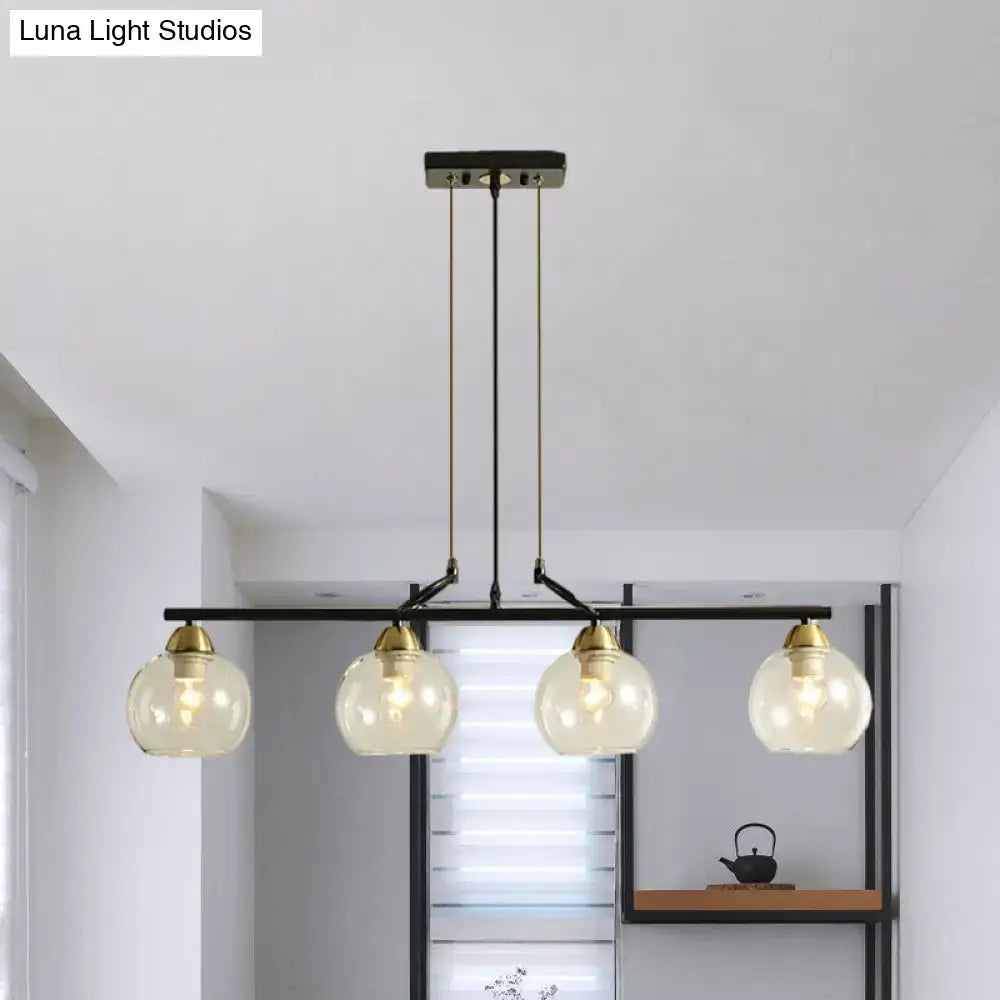 Modern black metal chandelier with brass accents and four clear prismatic glass globes for dining hall lighting