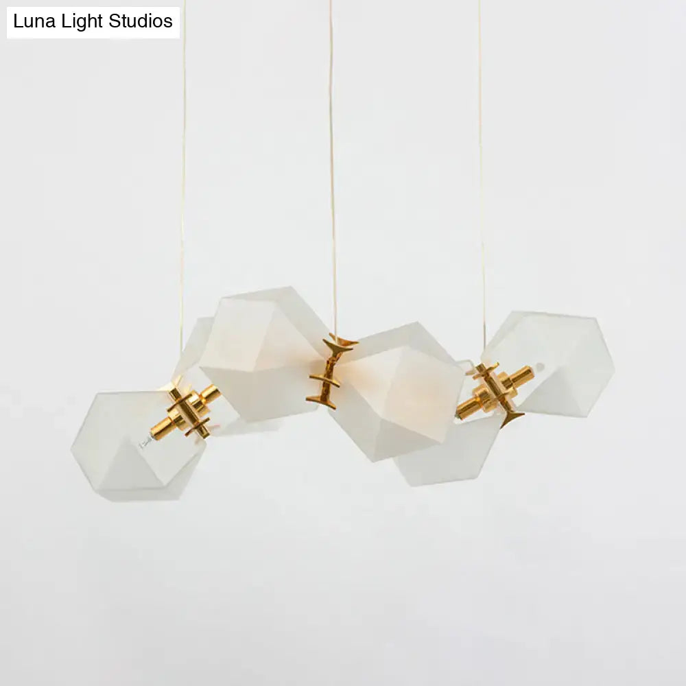 A modern decorbites frosted white glass honeycomb island lamp with brass ceiling hang and geometric faceted shades