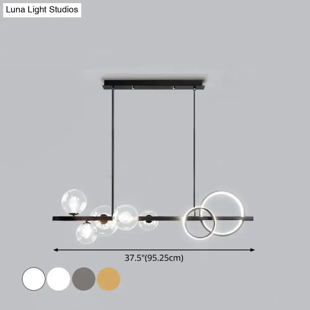 Modern black metal DecorBites™ island lamp with clear glass spheres and glowing rings for dining room lighting