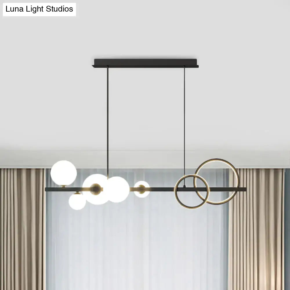 Modern black and brass decorbites island lamp with milk white glass bulbs and smoke grey circular rings for dining room