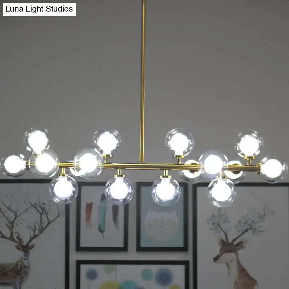 Gold-toned glass orb chandelier with 16 clear globe bulbs in a linear design for living room ceiling lighting