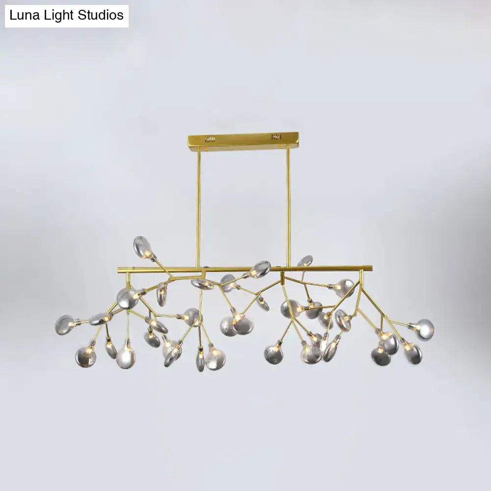 Gold-toned heracleum island pendant light with branching arms and clear teardrop glass bulbs for modern dining rooms