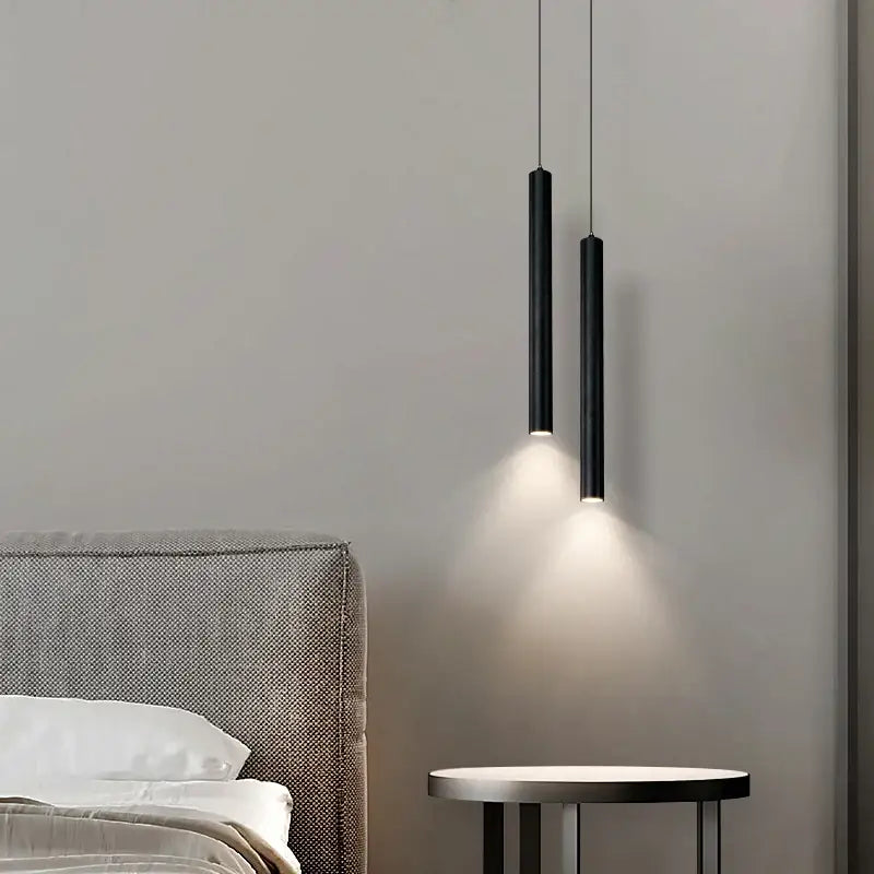 Two sleek black DecorBites™ contemporary nordic led pendant lights hang emitting warm dining room glow