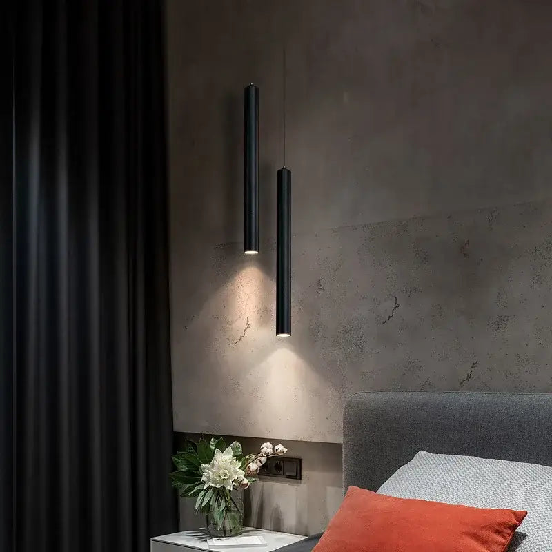 Two sleek black DecorBites™ nordic led pendant lights cast warm beams on a textured gray wall for dining room use