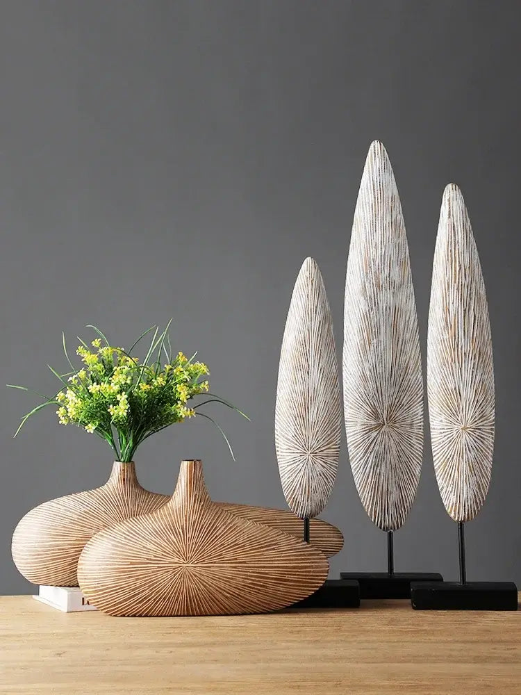 Set of three handcrafted wooden leaf sculptures with radial grain patterns displayed on black stands for contemporary resin vase décor