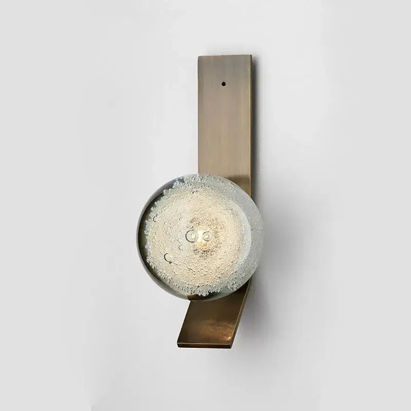 Decorbites™ contemporary wall light with brushed brass rectangular base and illuminated bubble-filled glass globe