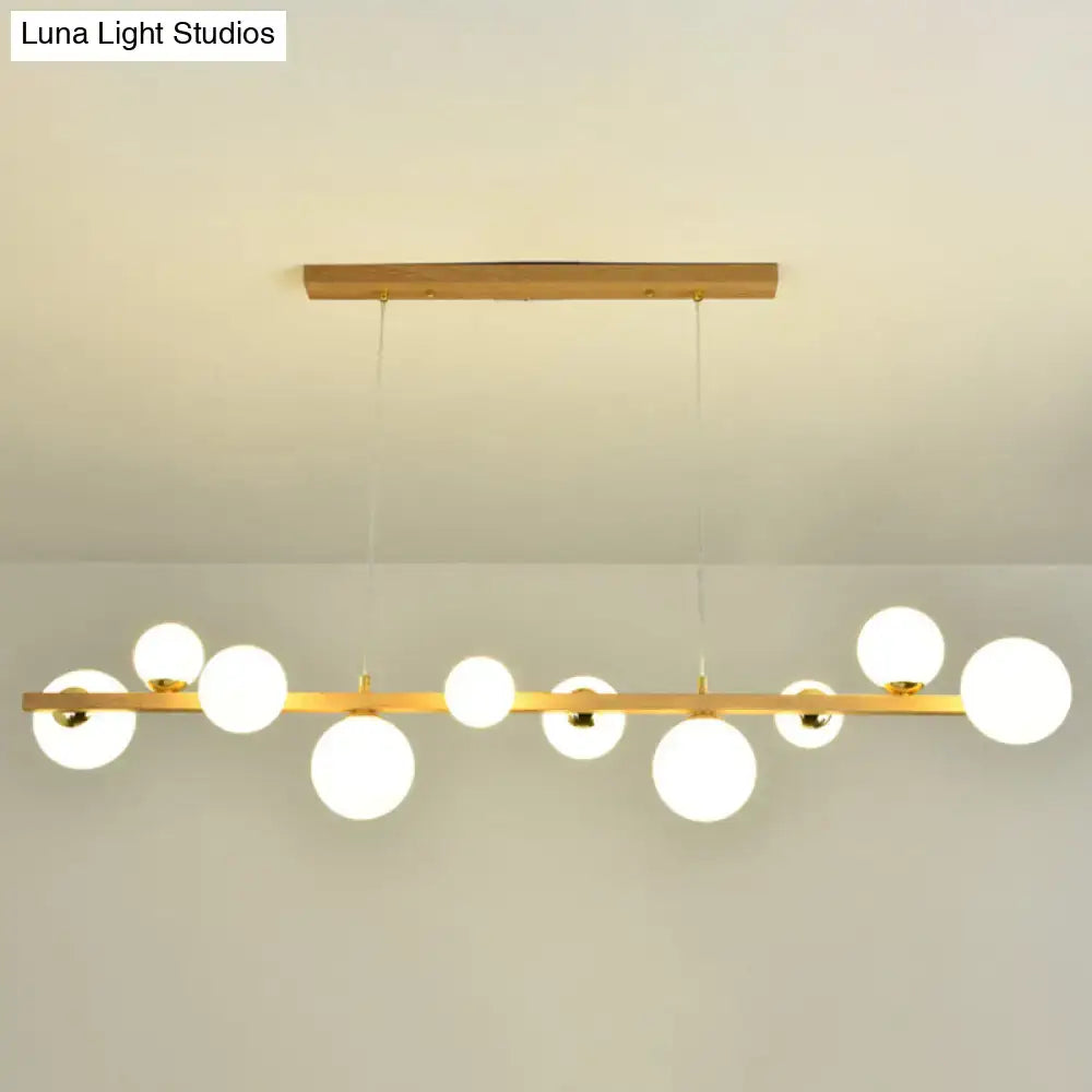 Decorbites™ contemporary wood pendant with gold-toned bar and globe shade designed for 110v-120v dining room lighting