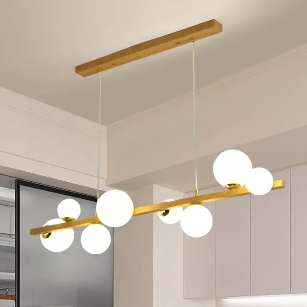 DecorBites contemporary wood pendant light with gold-toned bar and white glass globe shade for dining room 110v-120v