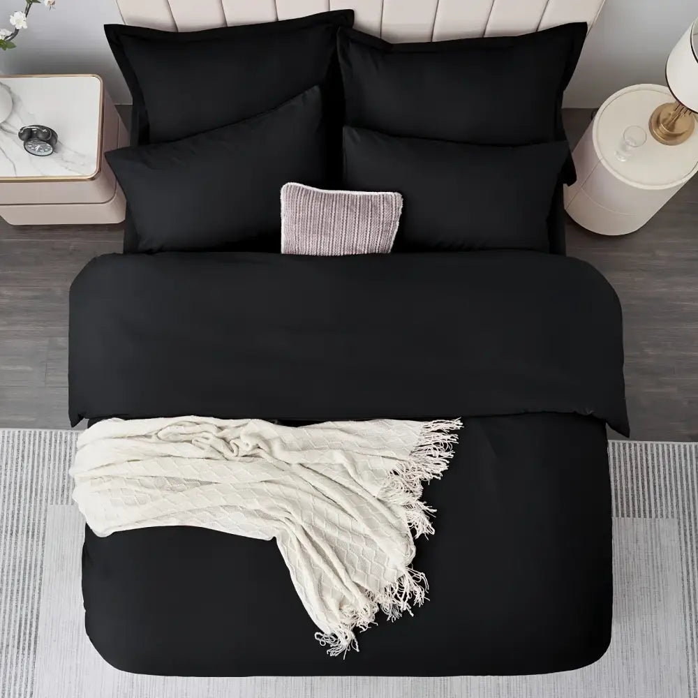 Black satin-like cotton duvet cover set with matching pillows and cream textured throw from DecorBites™ cooling summer collection