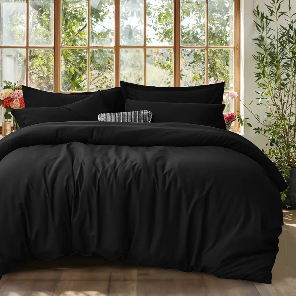 DecorBites™ black satin-like cotton duvet cover set with matching pillows and a textured accent pillow in center