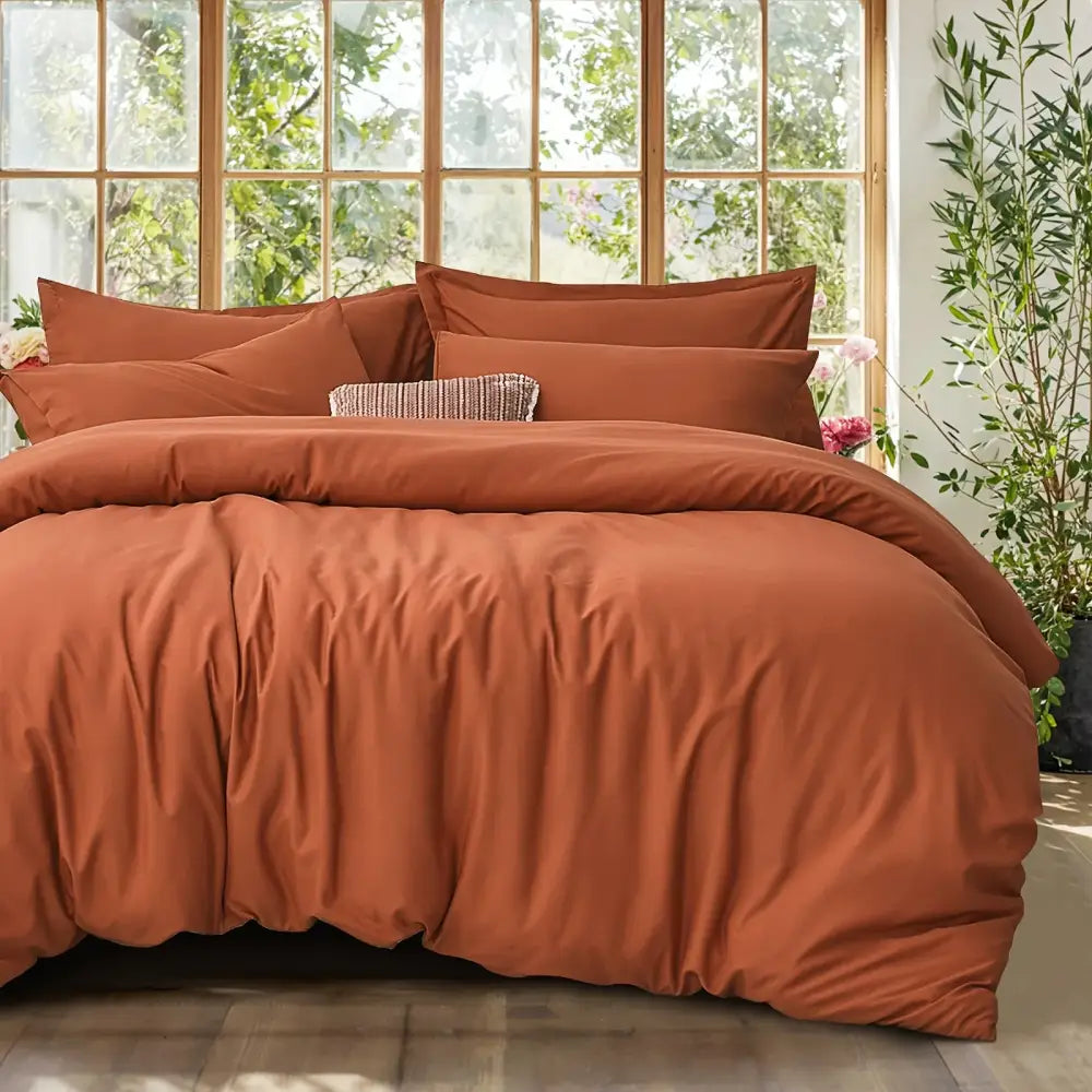 Rust-colored satin cotton duvet cover set with matching pillows and textured accent pillow by decorbites for summer use