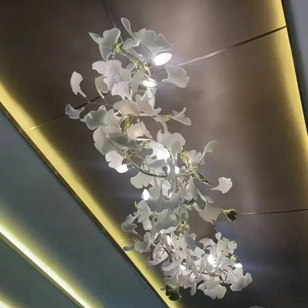 White ginkgo leaf chandelier lantern with translucent leaf-shaped glass elements and embedded lights for dining room luxury