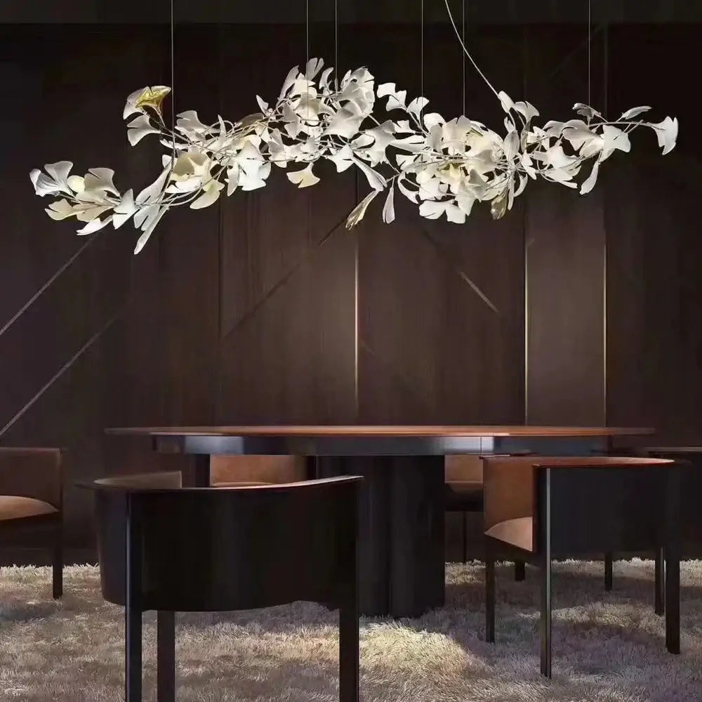 Elegant white ginkgo leaf chandelier lantern with sculpted branches suspended above modern dining table
