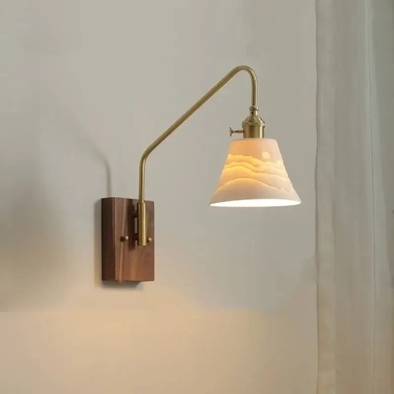 Modern brass and copper ceramic led wall lamp with warm-toned brass finish wooden base and off-white embossed ceramic shade