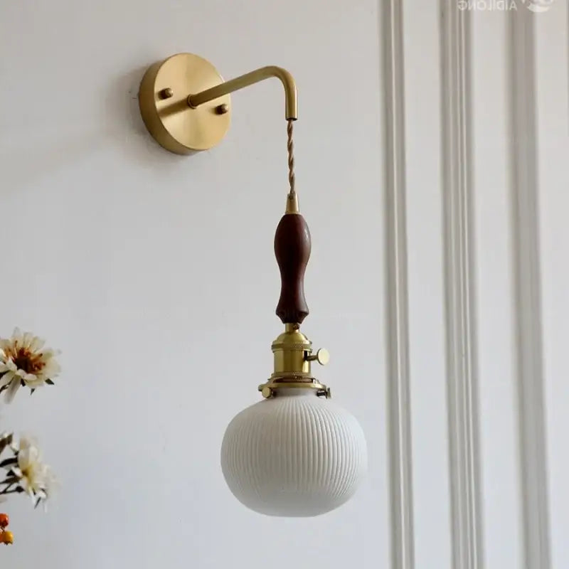 Vintage brass and dark wood led wall lamp with ribbed white glass globe shade and brass hardware for bedroom use