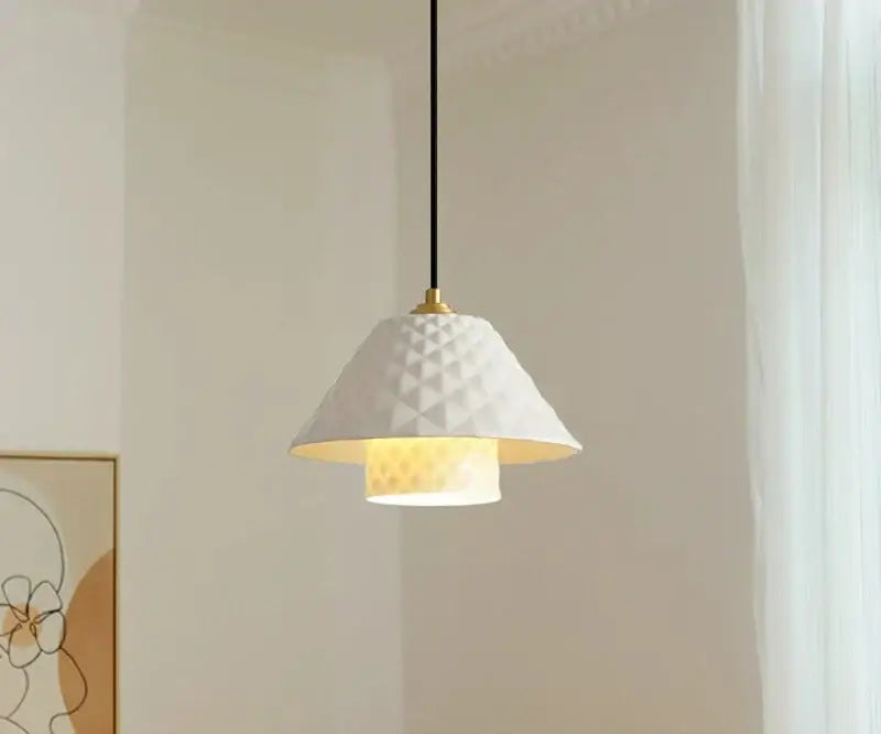 Textured white ceramic pendant light with gold-toned fixture and black cord for kitchen dining room lighting