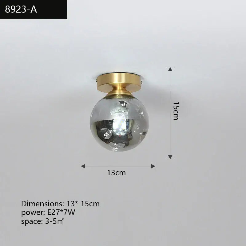 A sleek spherical glass globe ceiling light with a polished brass base in a modern decorbites copper chandelier design