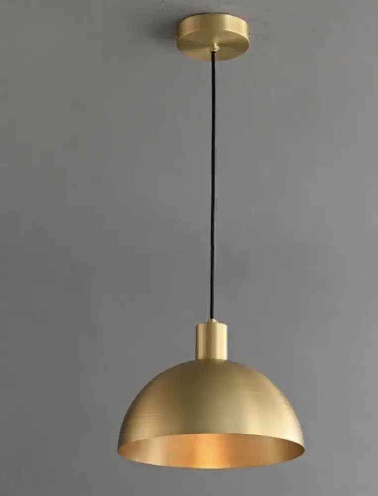 A sleek brushed gold dome pendant light with black cord in the decorbites copper chandelier collection