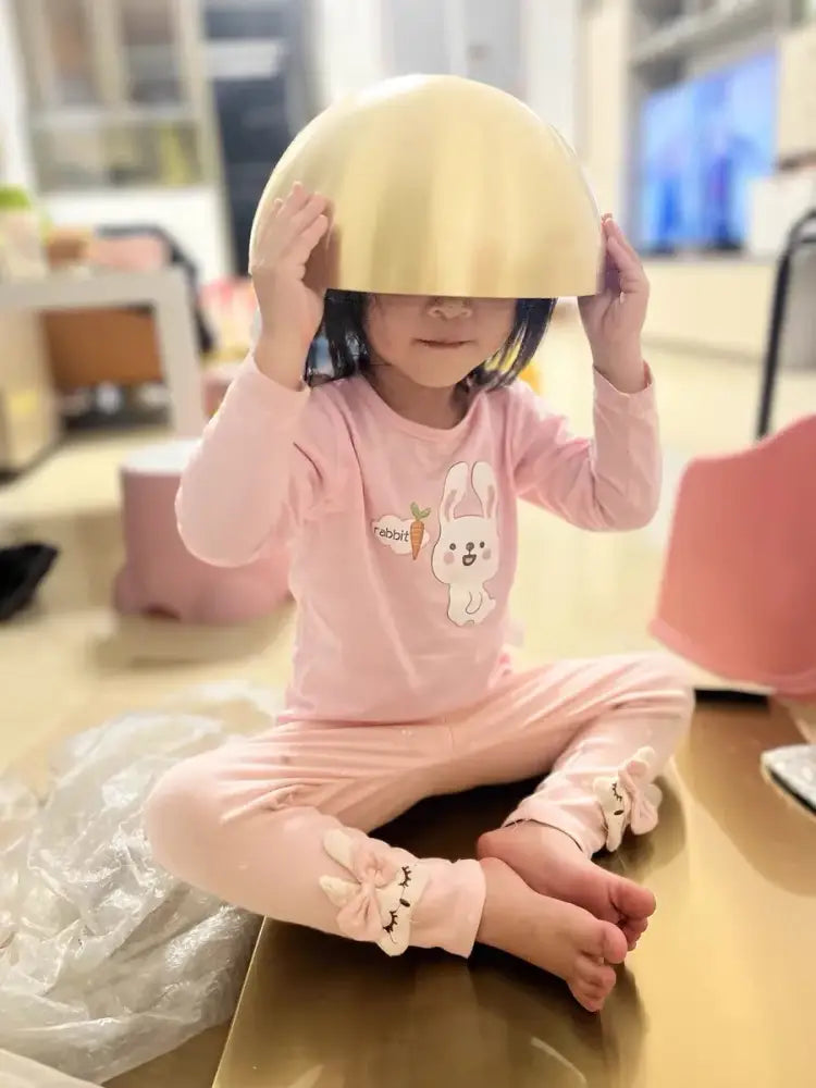 A child holds a shiny gold bowl under a decorbites copper chandelier brushed gold kitchen pendant light
