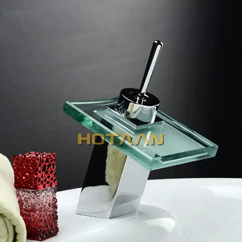 Modern chrome waterfall bathroom faucet with sleek angular design and transparent glass plate for white ceramic basin mixer