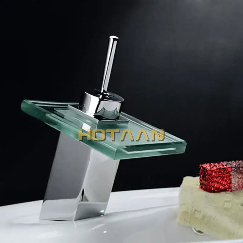 Modern chrome waterfall bathroom faucet with sleek angular design and transparent glass plate for white ceramic basin mixer