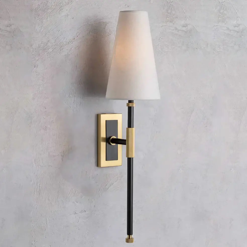 A sleek black and brass copper cloth led wall lamp with a tapered white fabric shade for bedroom reading