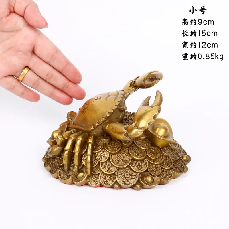 Golden brass copper crab ornament with detailed claws and shell atop ancient coin-like discs for luxury decor
