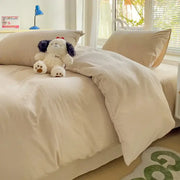Cream-colored soft textured cotton bedding set with duvet cover and plush stuffed dog toy on top by decorbites