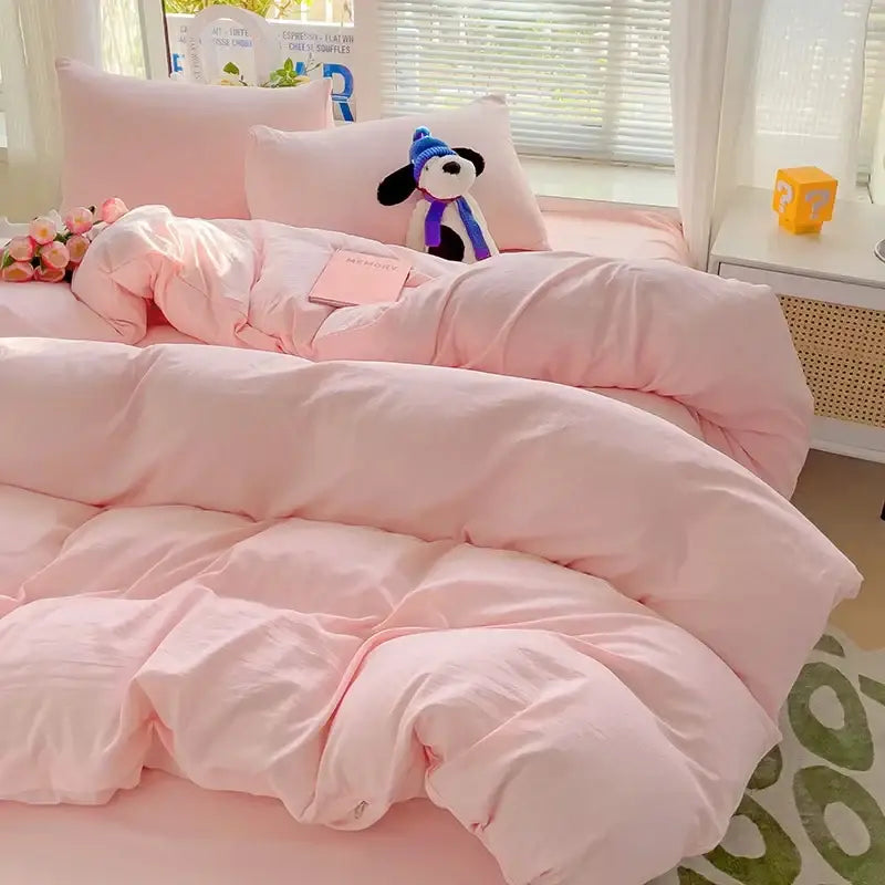 Soft pink quilted duvet cover from decorbites cotton bedding set with plush stuffed dog on pillows behind it