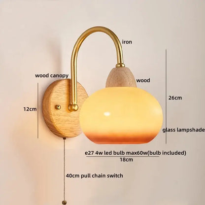 A warm-toned glass lampshade with brass iron arm and wooden canopy on a decorbites cotton led wall lamp