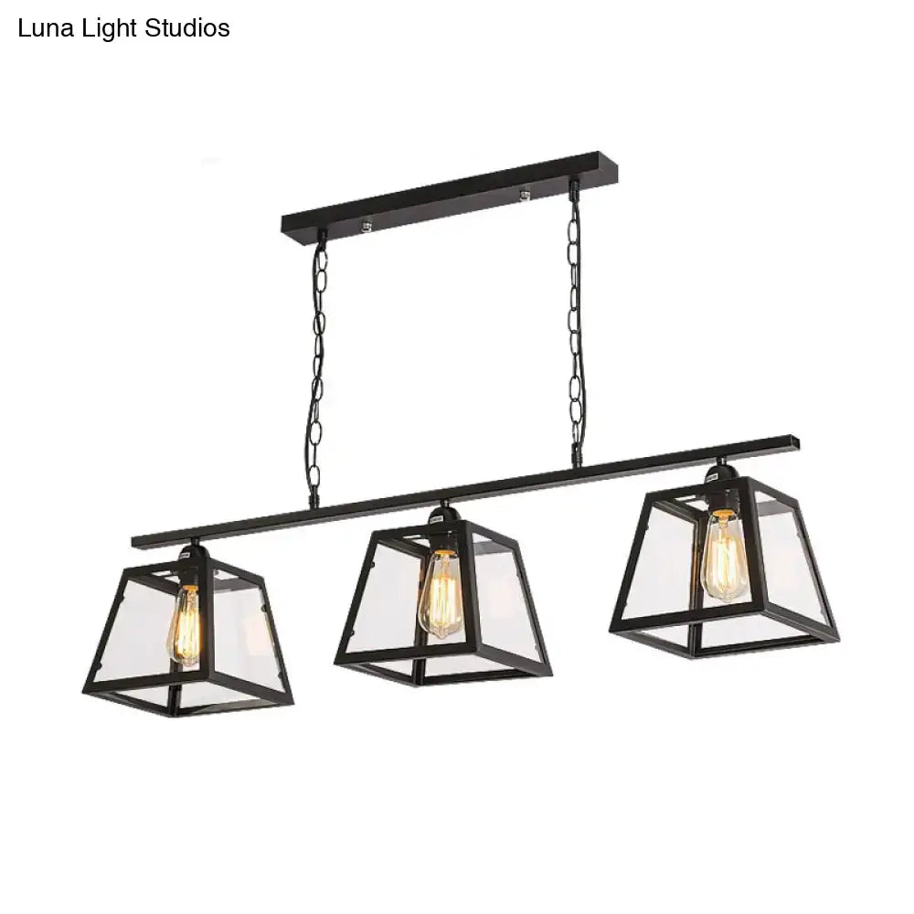 Black metal industrial island pendant light with three clear glass lanterns and exposed filament bulbs with chain cord length
