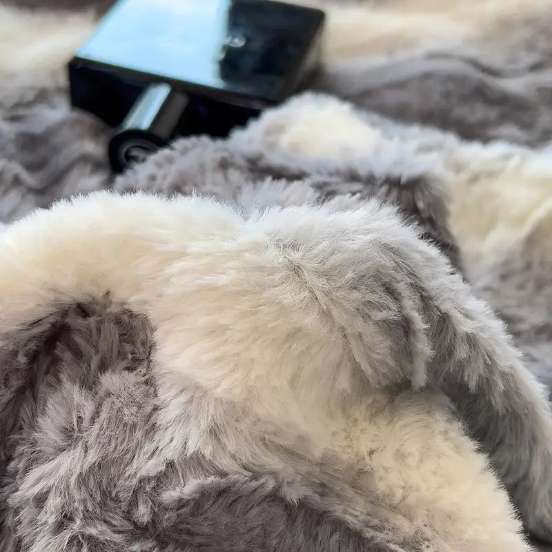 A plush two-toned gray and cream faux fur blanket from decorbites cozy faux bedding set for bedroom comfort