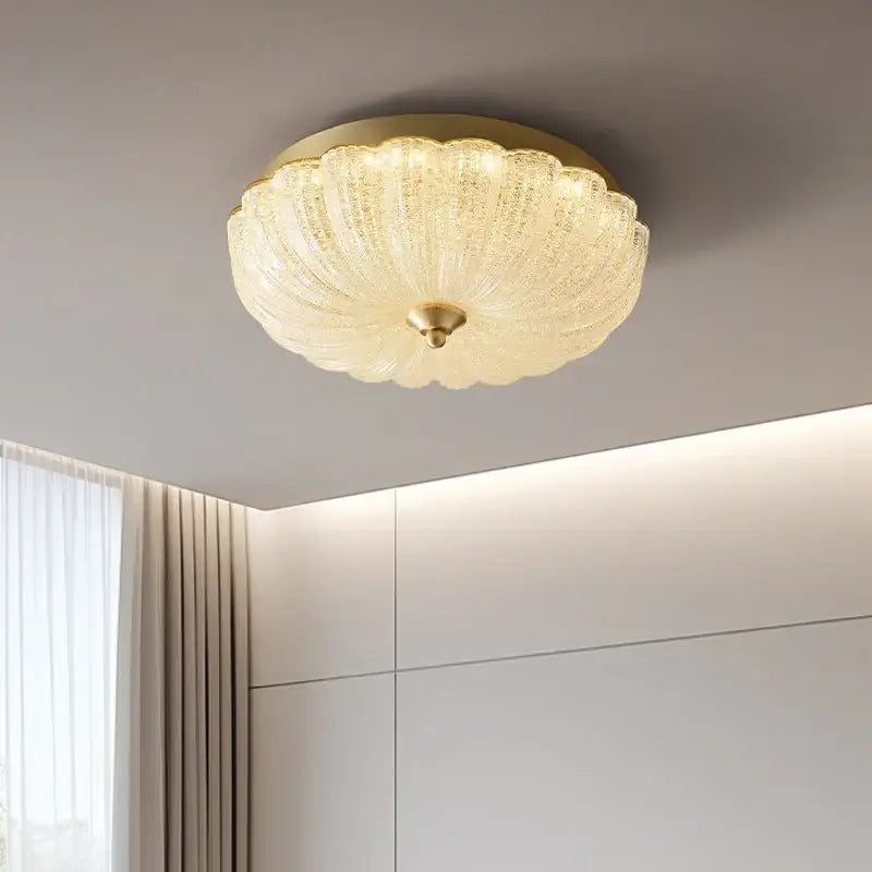 Decorbites cream air ceiling lamp with a gold ribbed textured glass shade shaped like an open flower for bedroom