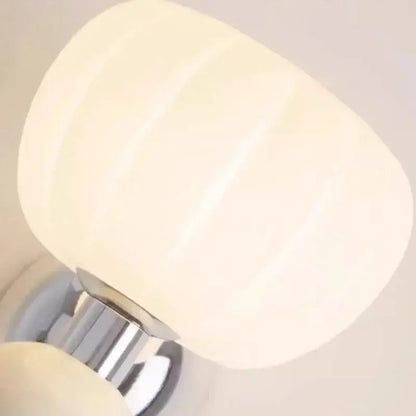 Decorbites cream breeze frosted glass pumpkin wall sconce featuring cream ribbed lampshade and polished chrome base