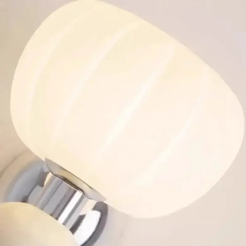 Decorbites cream breeze frosted glass pumpkin wall sconce featuring cream ribbed lampshade and polished chrome base