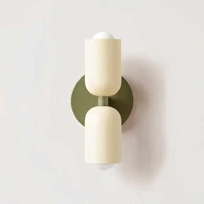 Cream double head wall lamp by Decorbites featuring cream cylindrical sconces with matte finish and olive green backplate