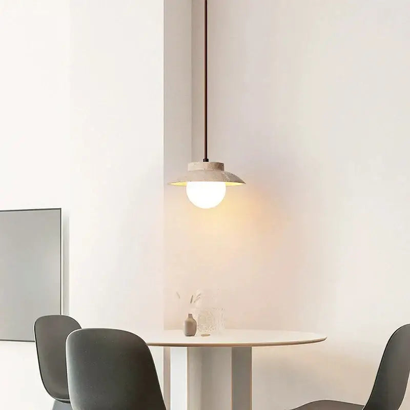 Minimalist pendant lamp with a cream stone chandelier matte concrete shade and warm-toned bulb by decorbites
