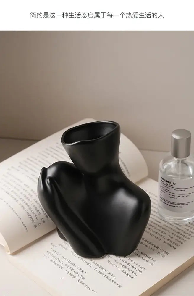 Black glossy ceramic human vase by DecorBites™ featuring an abstract stylized torso for modern home decor
