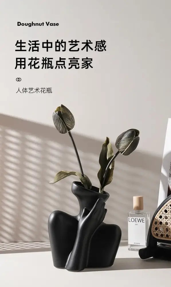 Black matte ceramic human vase in doughnut shape with sculpted form for minimalist home decor by DecorBites™
